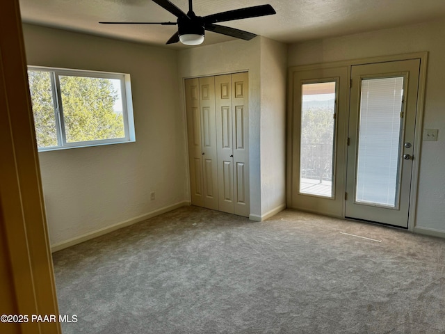 unfurnished bedroom with a closet, a textured ceiling, ceiling fan, light carpet, and access to exterior