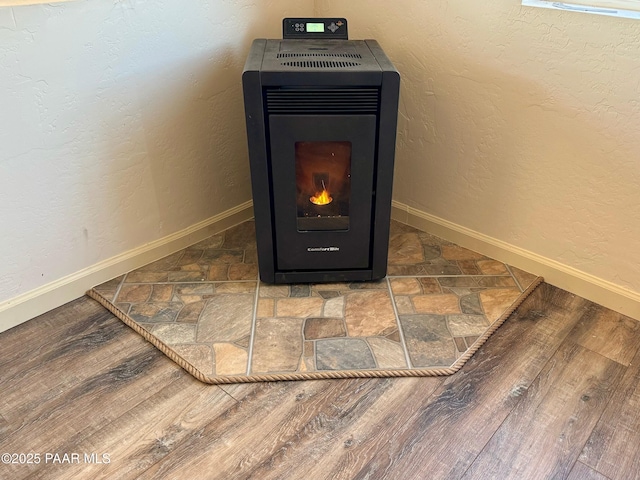 interior details with a wood stove and wood-type flooring