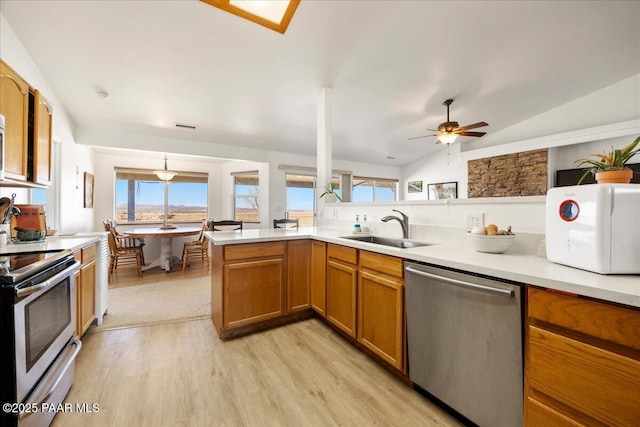 1250 Pronghorn Trl, Chino Valley, AZ 86323 - kitchen with stainless steel appliances, light wood-style floors, vaulted ceiling, brown cabinets, and a sink