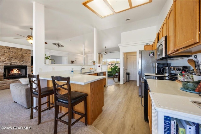 1250 Pronghorn Trl, Chino Valley, AZ 86323 - kitchen featuring appliances with stainless steel finishes, a kitchen bar, a sink, a ceiling fan, and a peninsula