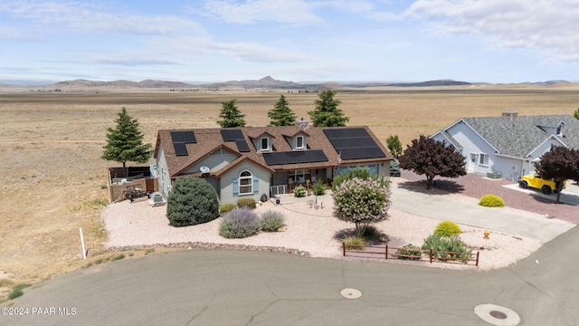 view of front of house with solar panels, a rural view, and a mountain view