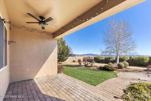 view of patio with a mountain view and ceiling fan