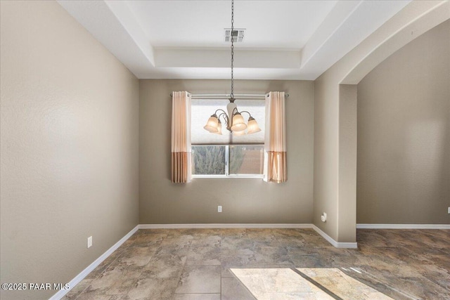 unfurnished dining area featuring an inviting chandelier and a raised ceiling