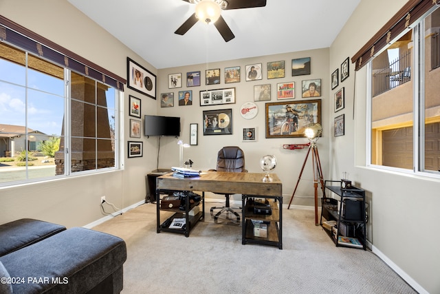 carpeted office space featuring ceiling fan and a healthy amount of sunlight