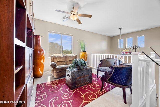 living area featuring ceiling fan and carpet flooring