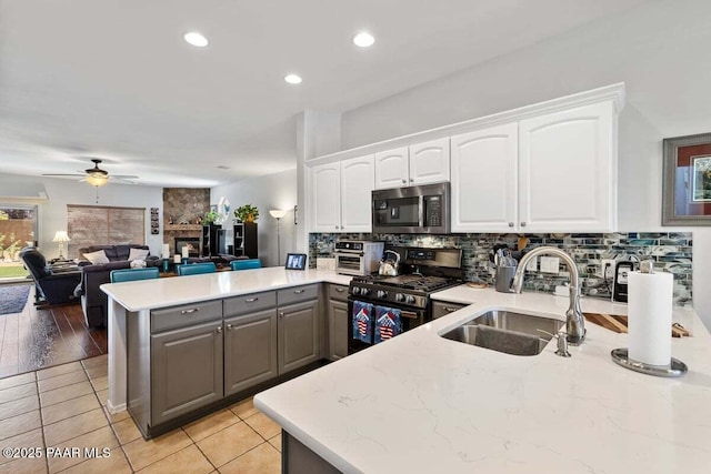 7605 E Circle Wagons Way, Prescott Valley, AZ 86315 - kitchen with stainless steel appliances, a peninsula, gray cabinetry, tasteful backsplash, and white cabinetry