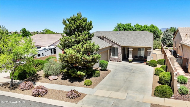 7334 E Goodnight Ln, Prescott Valley, AZ 86314 - view of front of house featuring an attached garage, driveway, stucco siding, a porch, and stone siding