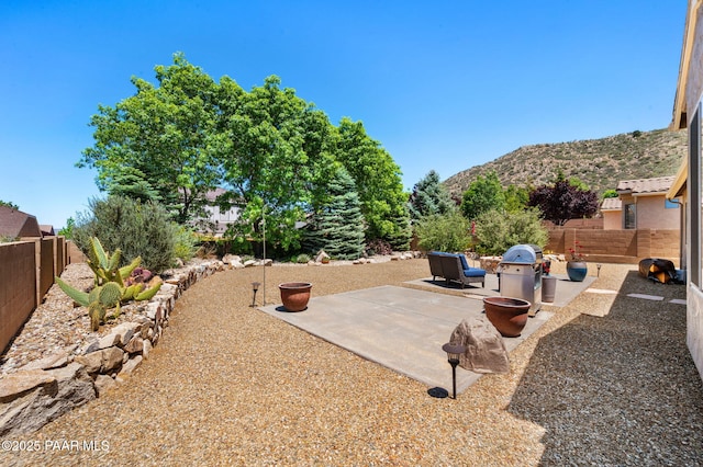 7334 E Goodnight Ln, Prescott Valley, AZ 86314 - fenced backyard featuring a mountain view, a patio area, and a grill