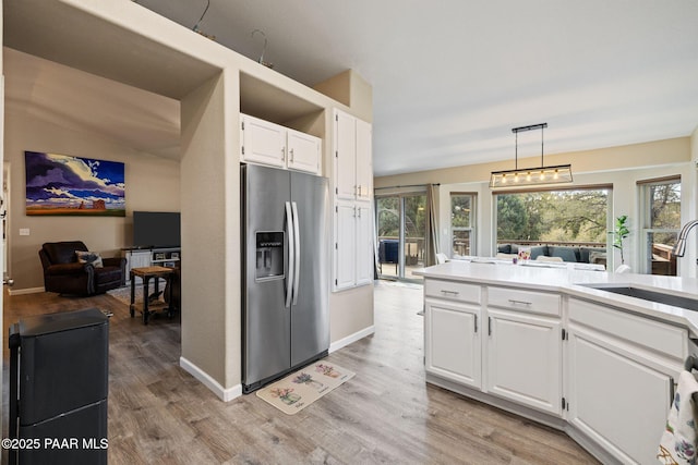 kitchen featuring a healthy amount of sunlight, stainless steel refrigerator with ice dispenser, and light wood-type flooring