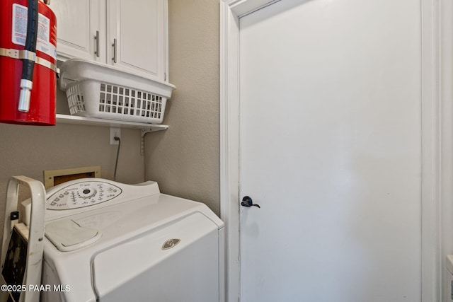 laundry room with cabinet space, independent washer and dryer, and a textured wall