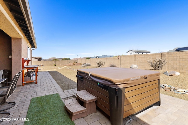 view of patio with a fenced backyard and a hot tub
