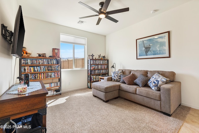 living room with baseboards, carpet flooring, ceiling fan, and visible vents