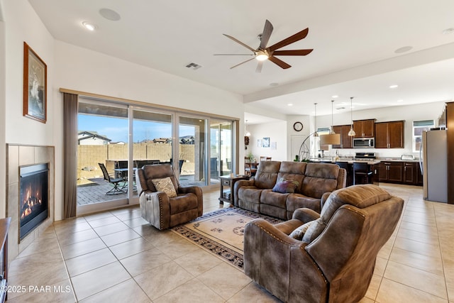 living room featuring recessed lighting, light tile patterned flooring, visible vents, a ceiling fan, and a tile fireplace