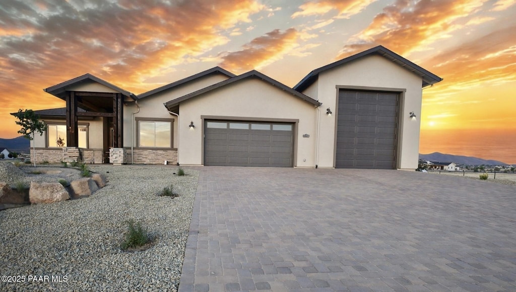 9827 N Constellation Ct, Prescott Valley, AZ 86315 - ranch-style house featuring stucco siding, a garage, decorative driveway, and stone siding