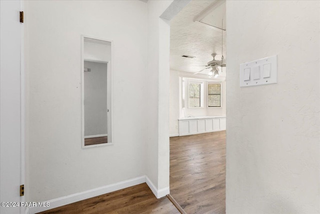 hall featuring a textured ceiling and hardwood / wood-style flooring