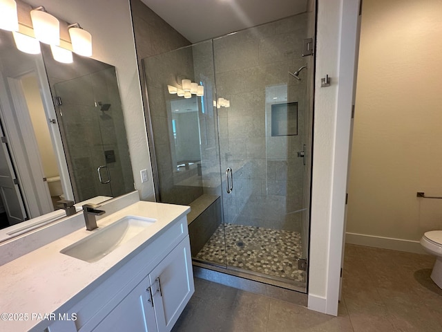 bathroom with a stall shower, tile patterned flooring, vanity, and toilet