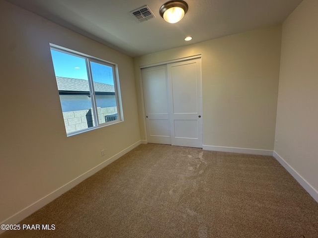 unfurnished bedroom featuring visible vents, baseboards, light colored carpet, a closet, and recessed lighting