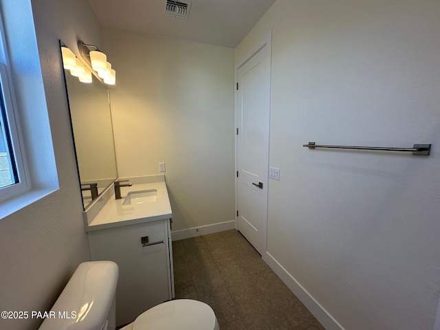 bathroom with toilet, baseboards, visible vents, and vanity