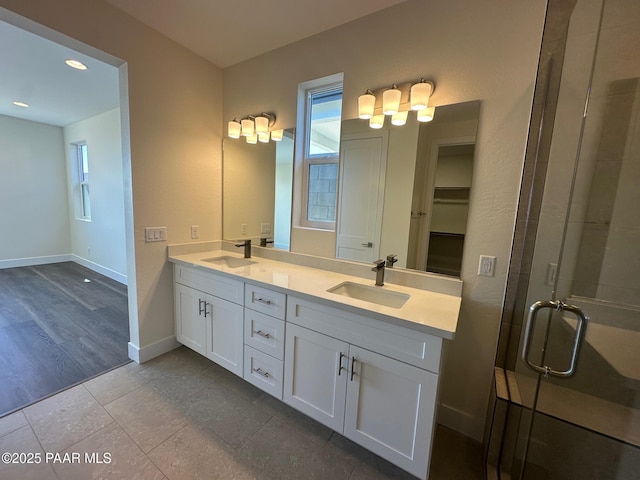 bathroom with a wealth of natural light, a shower stall, and a sink