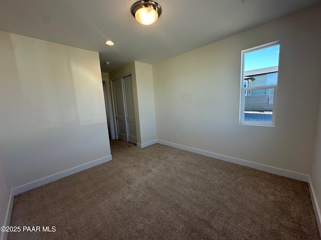 spare room featuring carpet floors, recessed lighting, and baseboards