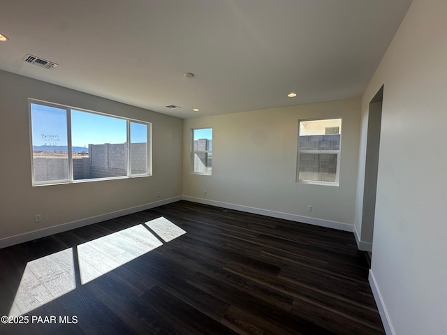 unfurnished room with recessed lighting, dark wood-style flooring, visible vents, and baseboards