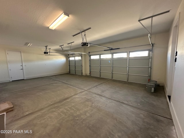 garage with baseboards and a garage door opener