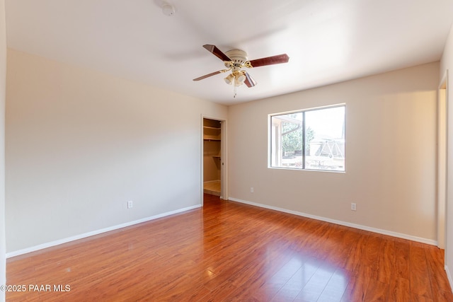 6333 E Lord Cir, Prescott Valley, AZ 86314 - unfurnished bedroom with a spacious closet, baseboards, a ceiling fan, a closet, and wood finished floors