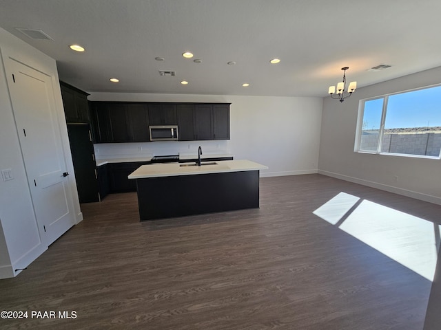 kitchen featuring sink, a center island with sink, a chandelier, range, and dark hardwood / wood-style floors