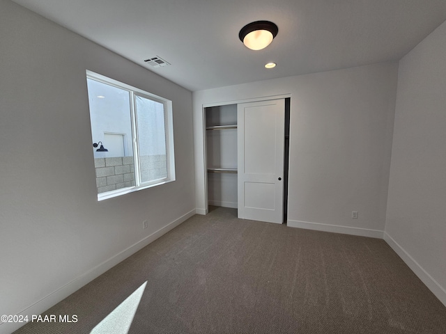 unfurnished bedroom featuring carpet floors and a closet