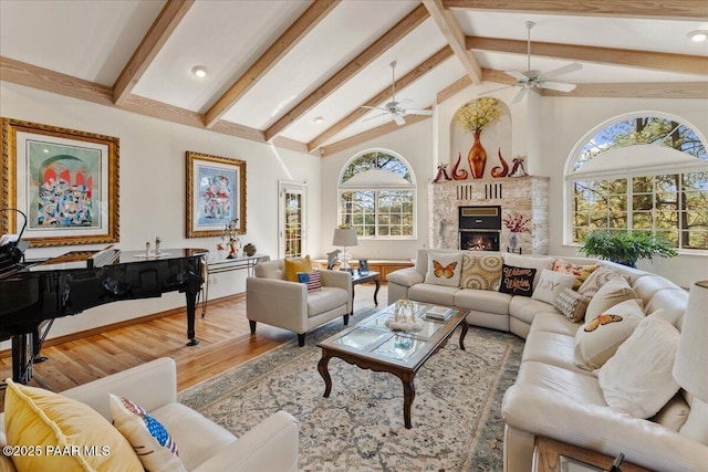 1167 Eagles Nest, Prescott, AZ 86303 - living area featuring a ceiling fan, wood finished floors, beamed ceiling, a lit fireplace, and high vaulted ceiling