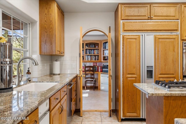 1167 Eagles Nest, Prescott, AZ 86303 - kitchen with light stone countertops, appliances with stainless steel finishes, tasteful backsplash, and brown cabinetry