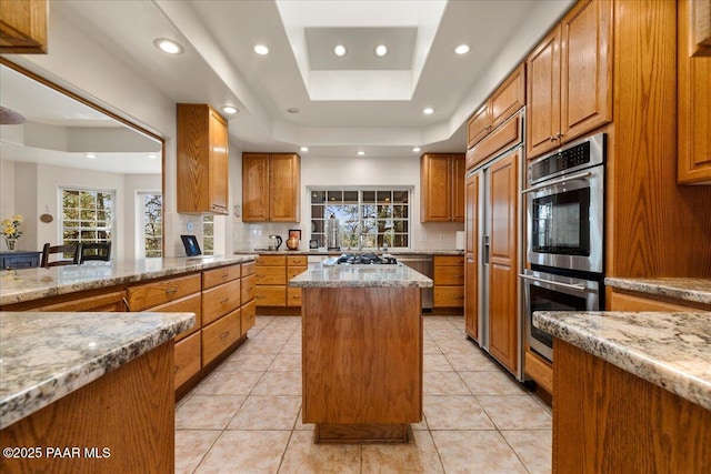 1167 Eagles Nest, Prescott, AZ 86303 - kitchen with light stone countertops, tasteful backsplash, recessed lighting, brown cabinetry, and a center island