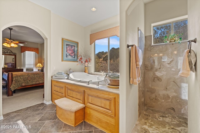 bathroom featuring a ceiling fan and ensuite bath