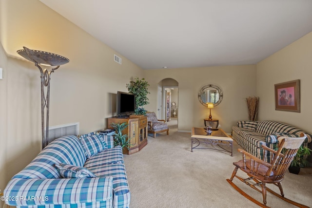 carpeted living area with visible vents and arched walkways