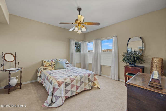 bedroom featuring light colored carpet, ceiling fan, and baseboards