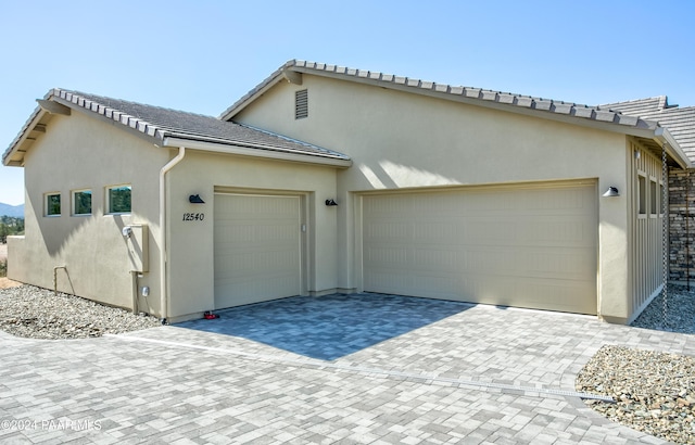 12290 N Thrine Cir, Prescott, AZ 86305 - exterior space featuring stucco siding, an attached garage, a tiled roof, and decorative driveway