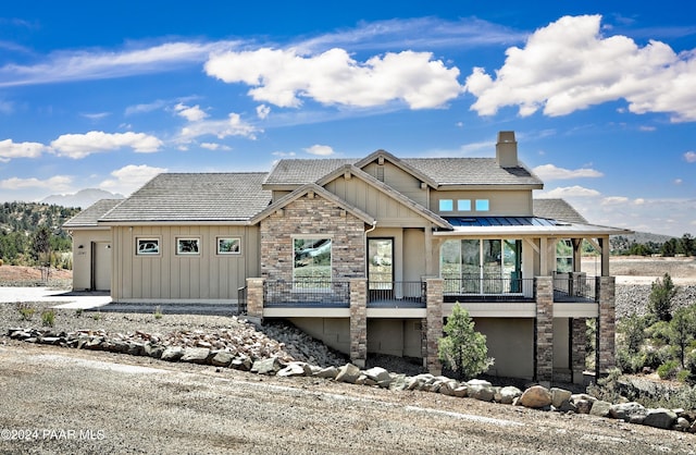 12290 N Thrine Cir, Prescott, AZ 86305 - view of front of house with a balcony, a chimney, an attached garage, board and batten siding, and stucco siding