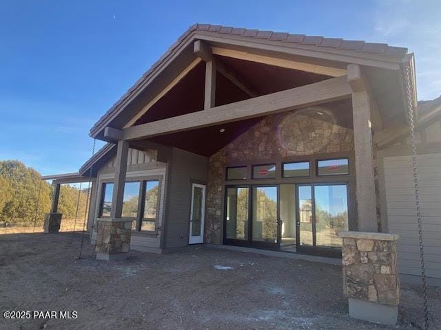 rear view of property featuring stone siding