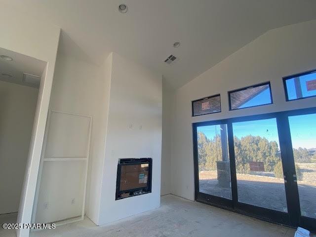 unfurnished living room featuring heating unit and lofted ceiling