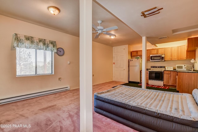 interior space featuring visible vents, a baseboard heating unit, and freestanding refrigerator