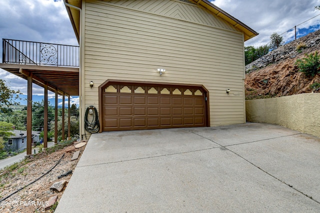 view of property exterior featuring a balcony and a garage