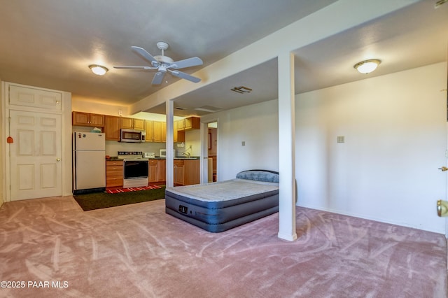 bedroom featuring light carpet, freestanding refrigerator, and a sink