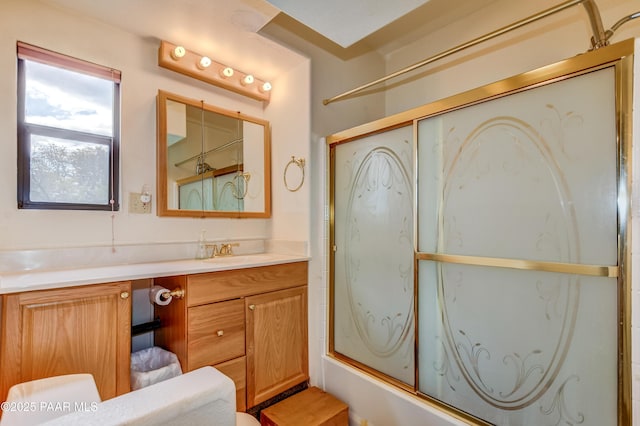 bathroom featuring combined bath / shower with glass door, toilet, and vanity