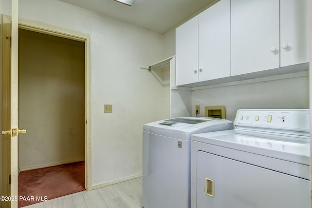 clothes washing area with light wood finished floors, cabinet space, baseboards, and separate washer and dryer