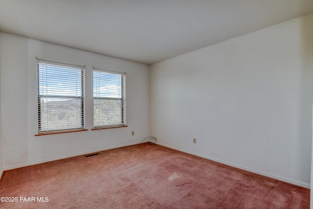 spare room featuring visible vents, carpet floors, and baseboards