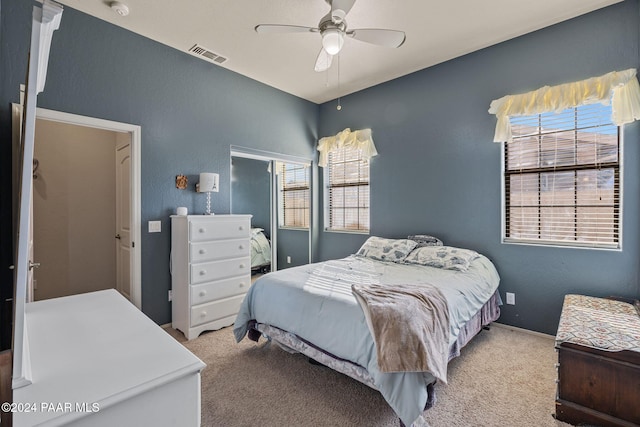 bedroom featuring light carpet, multiple windows, and ceiling fan