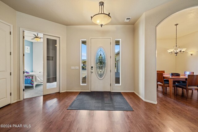 entrance foyer with dark hardwood / wood-style flooring and ceiling fan with notable chandelier