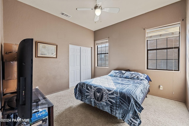 carpeted bedroom with ceiling fan and a closet