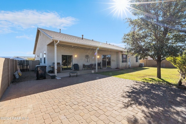 rear view of house with a yard and a patio