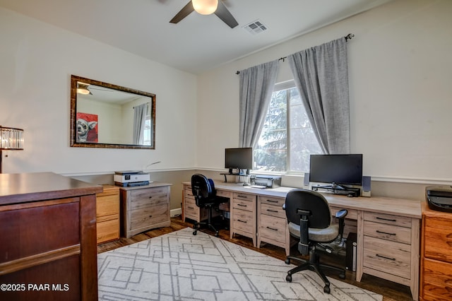 office area featuring baseboards, a ceiling fan, wood finished floors, and visible vents